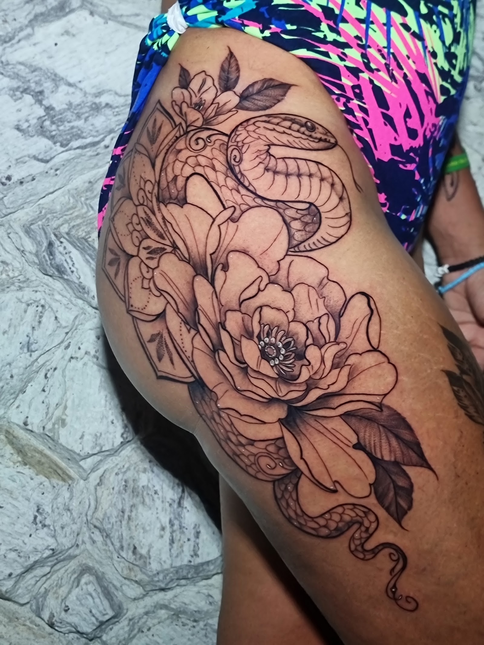 Tatuagem fineline de serpente com flores
